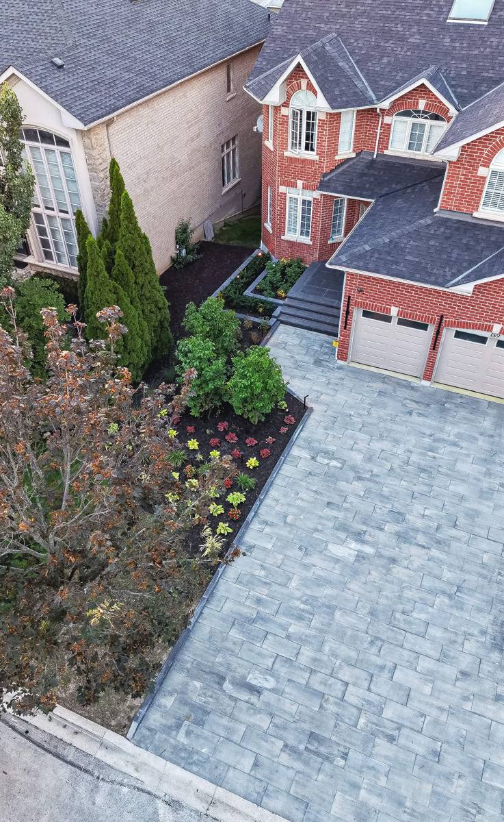Aerial view of an interlocking driveway with front gardens