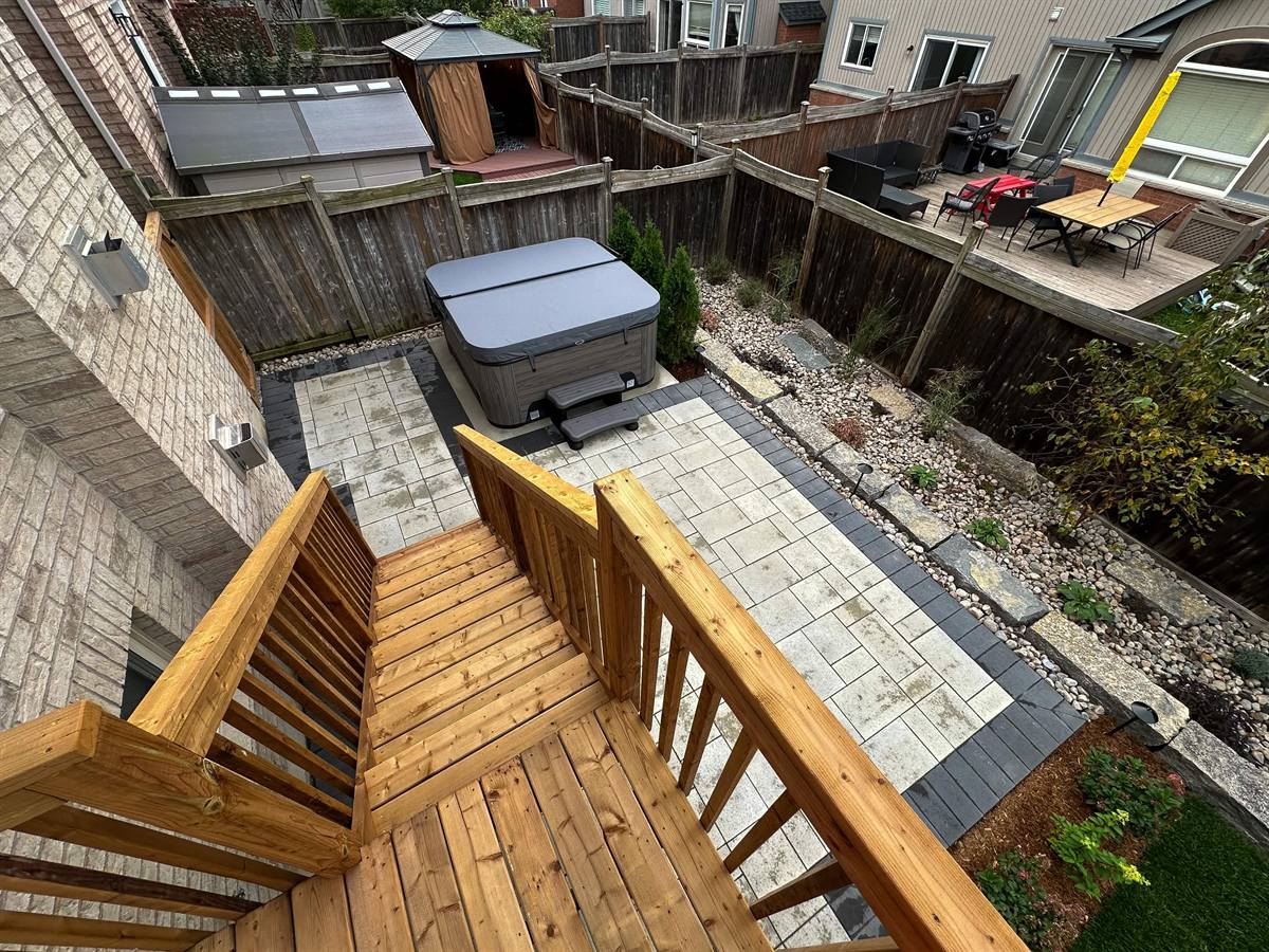 New paver patio with hot tub and cedar stairs
