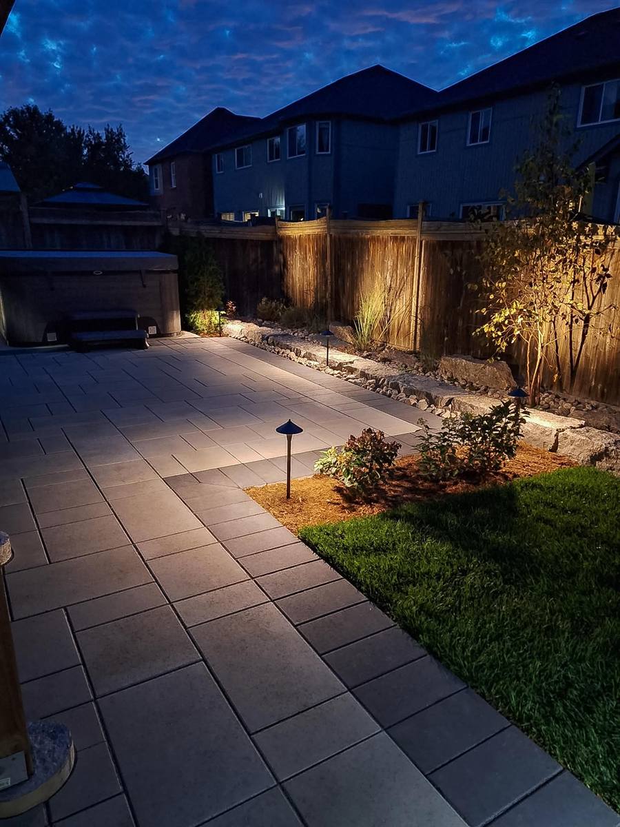 Backyard patio with path lights and garden lighting at night
