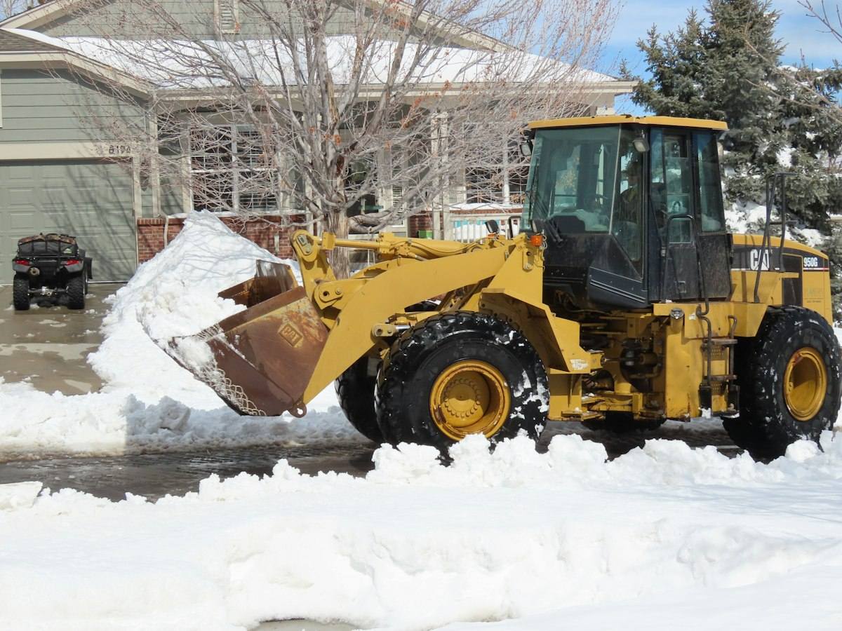 Loader clearing snow from a commercial lot