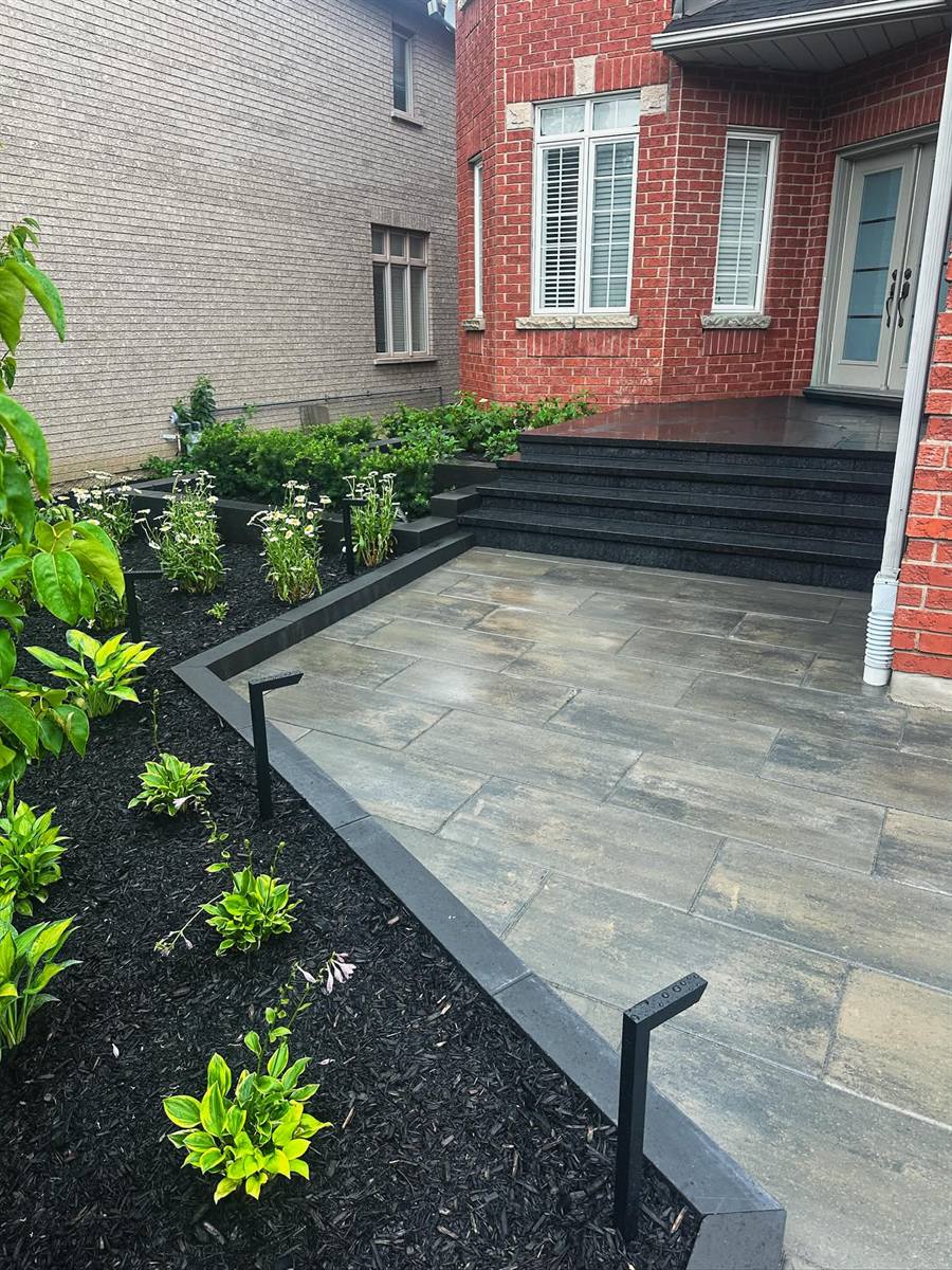 Front entrance with granite steps, slab landing and garden beds