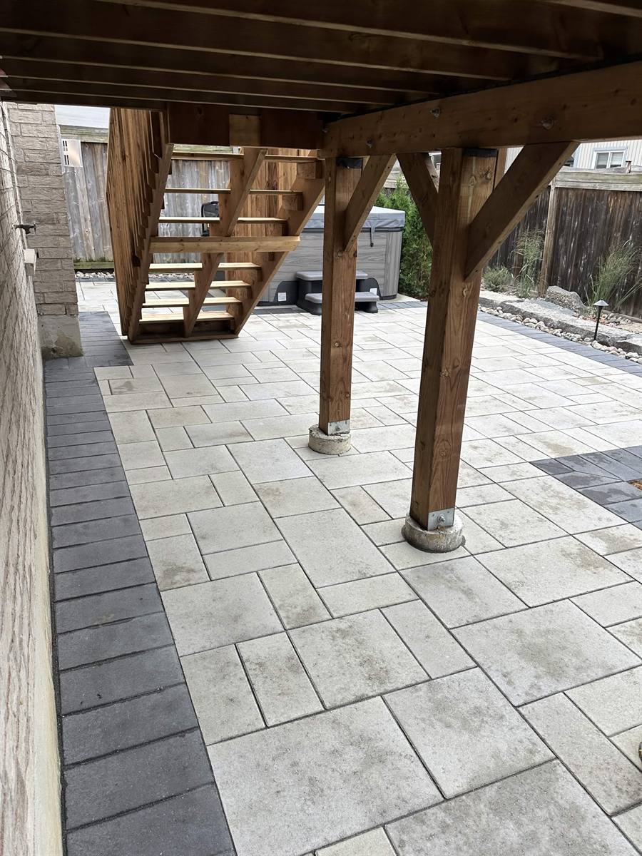 Under-deck paver patio with hot tub
